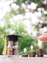 Glass bottle with graduation hat. Stack of coins with arrow rising icons. The concept of saving money for education, student loan Royalty Free Stock Photo