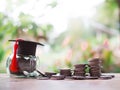 Glass bottle with graduation hat and stack of coins. The concept of saving money for education, student loan, scholarship, tuition Royalty Free Stock Photo