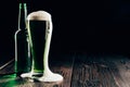 glass and bottle of green beer with foam on table, st patricks Royalty Free Stock Photo