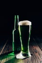 glass and bottle of green beer on wooden table, st patricks day concept Royalty Free Stock Photo