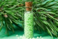 glass bottle with green granules and a pine branch. homeopathic remedies Royalty Free Stock Photo