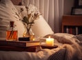 A glass bottle of home perfume stands adorned with wooden sticks, emanating a soothing fragrance. Scented candles emit