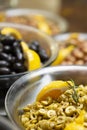 Glass bottle of homemade olive oil and olive tree branch, raw turkish green and black olive seeds and leaves on grey rustic table. Royalty Free Stock Photo