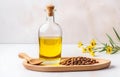 Glass bottle with jojoba oil and seeds on white wooden table soft light