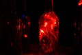 Glass bottle in laser lights. Royalty Free Stock Photo