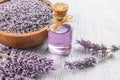 Glass bottle of Lavender essential oil with fresh lavender flowers and dried lavender seeds on white rustic table Royalty Free Stock Photo