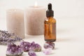 Glass bottle of Lavender essential oil with lavender flowers and candles and amethyst crystals Royalty Free Stock Photo