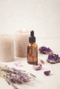 Glass bottle of Lavender essential oil with lavender flowers and candles and amethyst crystals Royalty Free Stock Photo