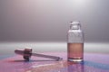 Glass bottle with liquid and godlen medicine dropper on glass background Royalty Free Stock Photo