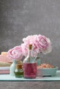 Glass bottle of liquid soap, bowl with sea salt and peonies in t