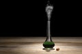 Glass bottle with magic green potion on a dark background. Royalty Free Stock Photo
