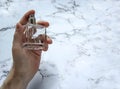 A glass bottle of male perfume in hand Royalty Free Stock Photo