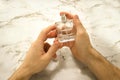 A glass bottle of male perfume in hand Royalty Free Stock Photo