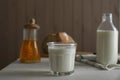 Glass and bottle of milk, honey with bread on white wooden table Royalty Free Stock Photo