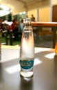 A glass bottle of mineral water stands on a table in a cafe Royalty Free Stock Photo