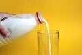 Milk is poured from a bottle into a glass Royalty Free Stock Photo