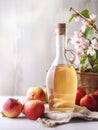 Glass bottle with natural cider vinegar and ripe apples on light wooden background, close-up, Provence style, vertical