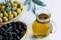 Glass bottle of olive oil and olive tree branch, raw turkish green olive seeds Royalty Free Stock Photo