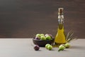 Glass bottle of olive oil and wooden breakfast bowl with raw turkish olive seeds and leaves on wooden rustic vintage table Royalty Free Stock Photo