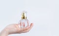 glass bottle with perfume in female hand isolated on white background Royalty Free Stock Photo