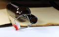 Glass bottle with plastic stopper on antique book Royalty Free Stock Photo