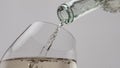 Glass bottle pouring wine in goblet closeup. Sparkling champagne bubbling inside Royalty Free Stock Photo