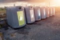 Glass bottle recycling facility at sunrise.Raw of plastic containers for glass collection. Warm sunrise time. Sun flare. Nobody