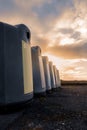 Glass bottle recycling facility at sunrise.Raw of plastic containers for glass collection. Warm sunrise time. Sun flare. Nobody.