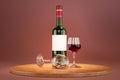 Glass bottle of red wine with blank white label on red background. Mockup template. bottle, two glasses on wooden tray. 3d Royalty Free Stock Photo