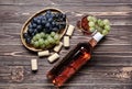 Glass and bottle of red wine with fresh grapes on wooden table Royalty Free Stock Photo