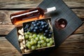 Glass and bottle of red wine with fresh grapes on wooden table Royalty Free Stock Photo