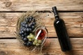 Glass and bottle of red wine with fresh grapes on wooden table Royalty Free Stock Photo