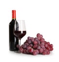 Glass and bottle of red wine with ripe grapes on white background Royalty Free Stock Photo