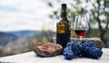 Glass bottle and glass of red wine on stone table Royalty Free Stock Photo