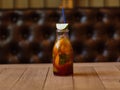A glass bottle with a refreshing cool beverage, a slice of fragrant lime on a blurred wooden background. Royalty Free Stock Photo