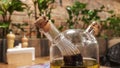 Glass bottle with sauce and butter for pizza and pasta, standing on a served wooden table in an Italian restaurant with brick