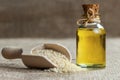 Glass bottle of sesame oil and raw sesame seeds in wooden shovel or spoon on burlap sack Royalty Free Stock Photo