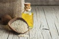 Glass bottle of sesame oil and raw sesame seeds in wooden shovel or spoon on burlap sack Royalty Free Stock Photo