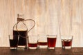 Glass bottle and shots on the wooden background