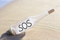 Glass bottle with SOS message on sand near sea Royalty Free Stock Photo