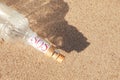 Glass bottle with SOS message on sand, top view Royalty Free Stock Photo