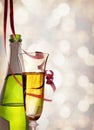 Glass and bottle of sparkling white wine and ribbons hanging
