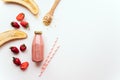 Glass bottle with strawberry-banana smoothie  drink, top view, paper tubes and ingredients. Superfoods and healthy lifestyle or de Royalty Free Stock Photo