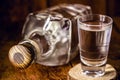 Glass and bottle of strong distilled alcohol, brandy, sugar cane-based drink