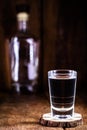 Glass and bottle of strong distilled alcohol, brandy, sugar cane-based drink