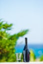 Glass and bottle of tasty red wine on balcony in greek island with view of sea Royalty Free Stock Photo