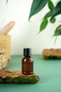 Glass bottle with tea tree essential oil standing on the bark of a tree. Cosmetic essence. Fresh green branches and Royalty Free Stock Photo