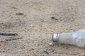 Glass bottle trash dropped on the beach environmental pollution Royalty Free Stock Photo