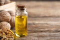 Glass bottle with walnut oil and walnut kernel on a wooden table. Royalty Free Stock Photo