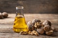 Glass bottle with walnut oil and walnut kernel on a wooden table. Royalty Free Stock Photo